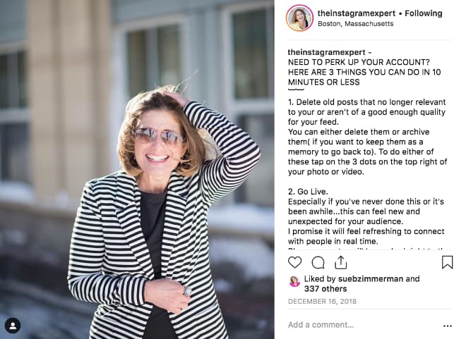Sue B Zimmerman's Instagram post shows her smiling and posing with a striped blazer and sunglasses on.