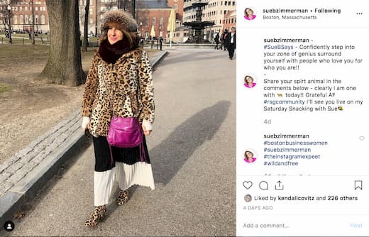 Sue B Zimmerman walks down the street in Boston in a leopard print coat and hat. 